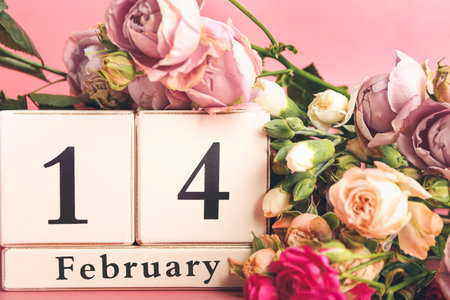 Calendar with date of Valentines Day and rose flowers on color backgroundの写真素材