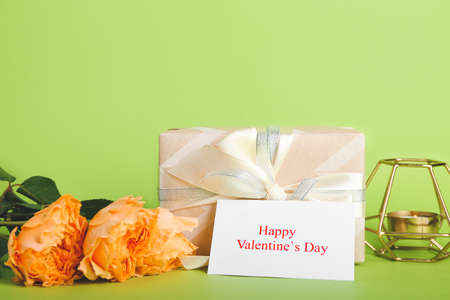 Gift, rose flowers and greeting card for Valentines Day celebration on color backgroundの写真素材