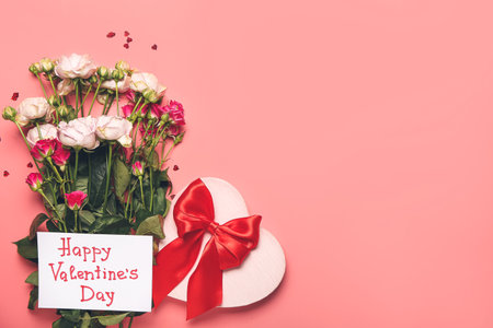 Gift, rose flowers and greeting card for Valentines Day celebration on color backgroundの写真素材