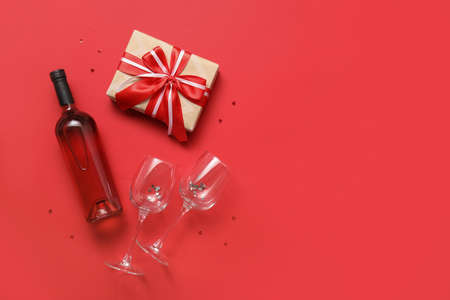 Bottle of wine, glasses and gift for Valentine's Day on color backgroundの写真素材
