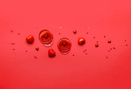Glasses of wine and hearts on color background. Valentine's day celebrationの写真素材