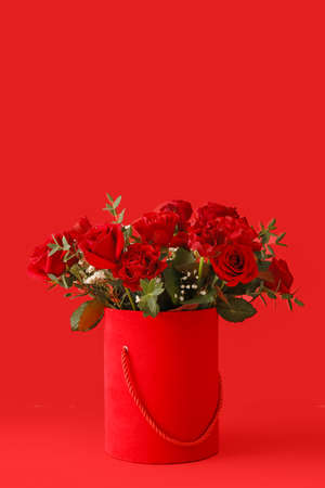 Gift box with beautiful flowers on color backgroundの写真素材