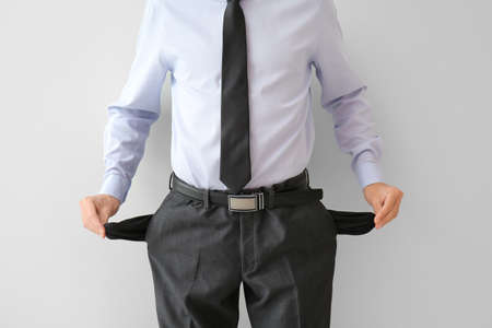 Businessman with empty pockets on white background. Bankruptcy conceptの写真素材