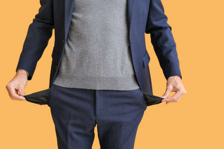 Man with empty pockets on color background. Bankruptcy conceptの写真素材