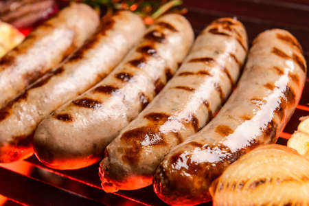 Delicious sausages cooking on grillの写真素材