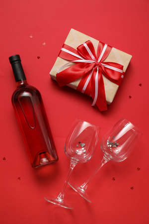 Bottle of wine, glasses and gift for Valentine's Day on color backgroundの写真素材