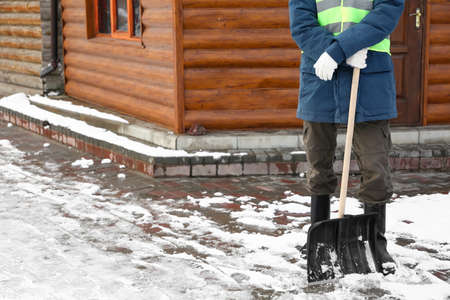Man removing snow with shovel on winter dayの写真素材