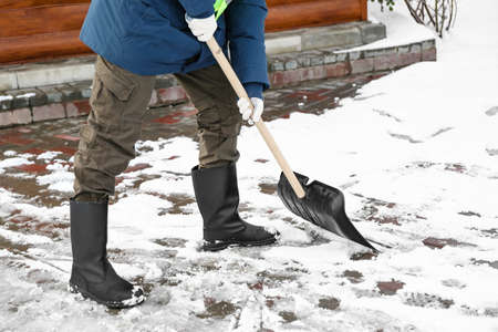 Man removing snow with shovel on winter dayの写真素材