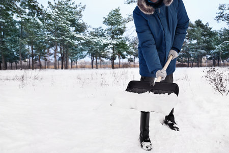 Man removing snow with shovel on winter dayの写真素材