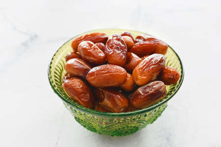Bowl with sweet dried dates on light background, closeupの写真素材