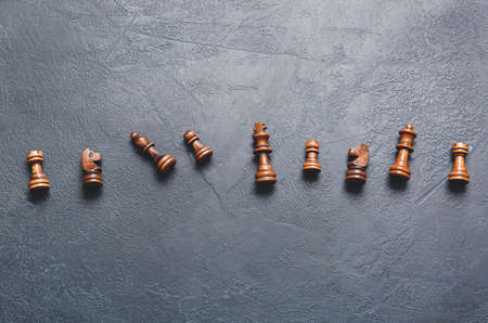 Wooden chess pieces on dark background