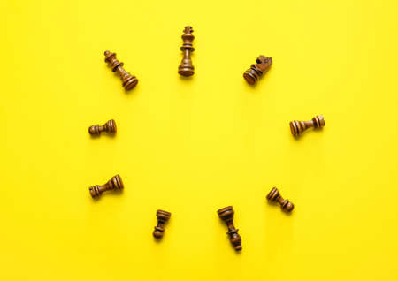 Frame made of chess pieces on color background