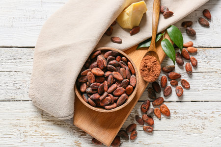 Bowl with cocoa beans and powder on white wooden backgroundの写真素材