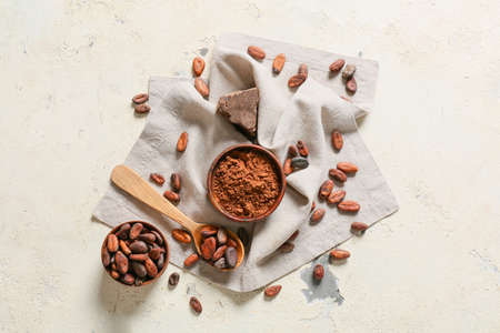 Bowls with cocoa beans and powder on light backgroundの写真素材