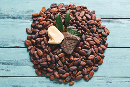 Cocoa beans and butter on color wooden backgroundの写真素材