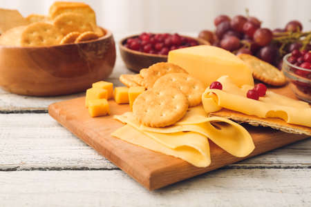 Platter with crunchy crackers and cheese on white wooden backgroundの写真素材