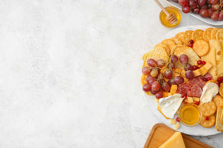 Platter with crunchy crackers and honey on light backgroundの写真素材