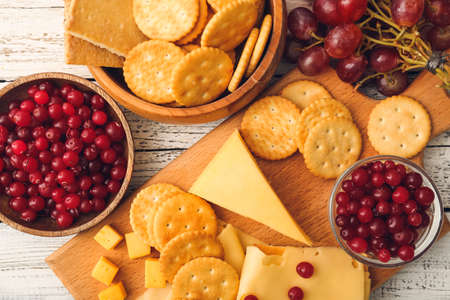 Crunchy crackers with cheese and cranberry on white wooden backgroundの写真素材