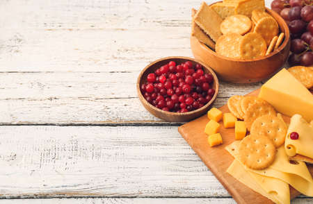 Crunchy crackers with cheese and cranberry on white wooden backgroundの写真素材