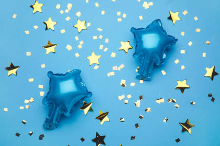 Balloons in shape of stars and confetti on color backgroundの写真素材