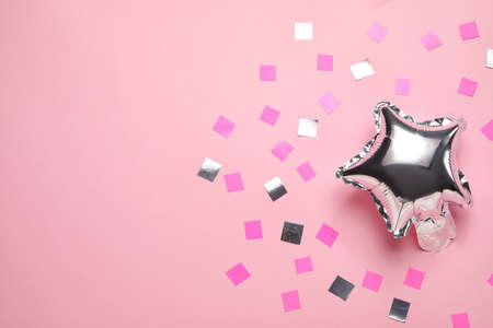 Balloon in shape of star and confetti on color backgroundの写真素材