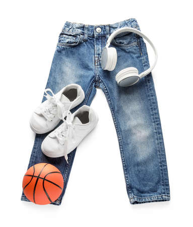Child's jeans with ball and headphones on white backgroundの写真素材