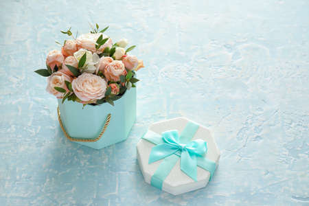 Gift box with beautiful flowers on color backgroundの写真素材