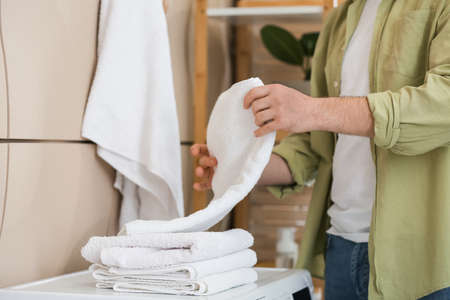 Man with clean towels in bathroomの写真素材