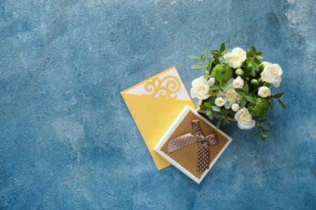 Gift box with beautiful flowers and card on color backgroundの写真素材