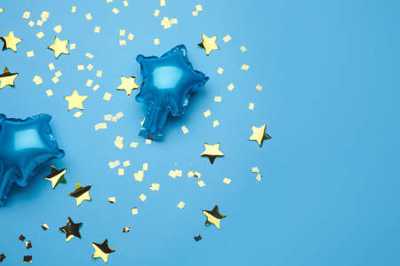 Balloons in shape of stars and confetti on color backgroundの写真素材