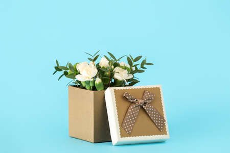Gift box with beautiful flowers on color backgroundの写真素材