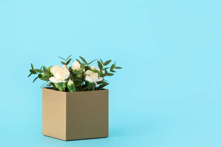 Gift box with beautiful flowers on color backgroundの写真素材