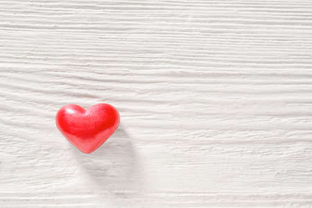 Red heart on white wooden backgroundの写真素材