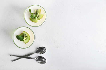Glasses of tasty jelly with kiwi on light backgroundの写真素材
