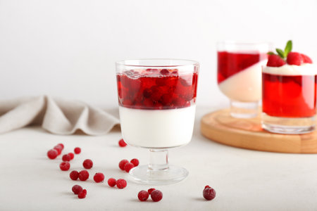 Glass of tasty cranberry jelly on light backgroundの写真素材