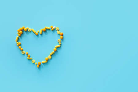 Heart made of pills on color backgroundの写真素材
