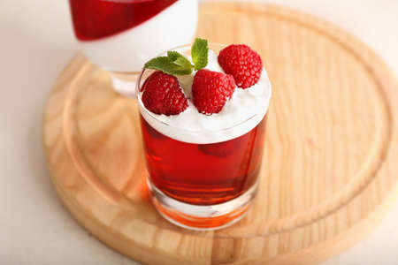 Glass of tasty raspberry jelly on light backgroundの写真素材