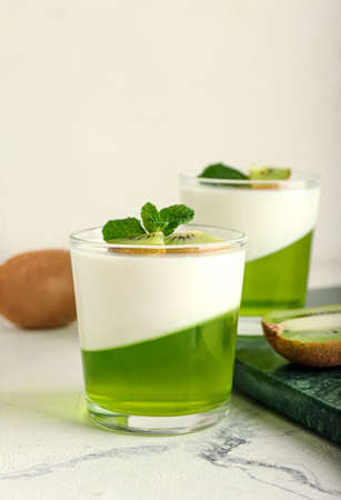 Glasses of tasty jelly with kiwi on light backgroundの写真素材