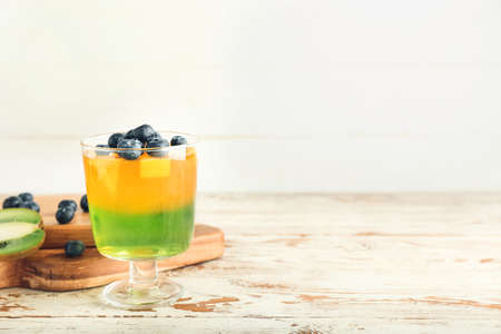 Glass of tasty jelly on light wooden backgroundの写真素材