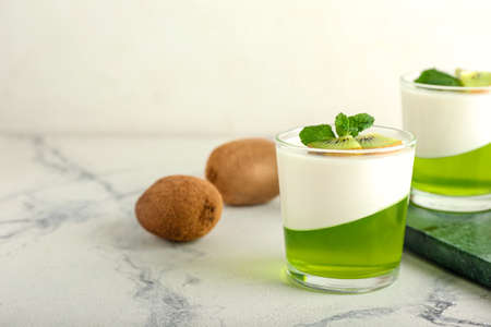 Glasses of tasty jelly with kiwi on light backgroundの写真素材