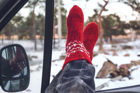 Legs of woman sitting in car on winter dayの写真素材