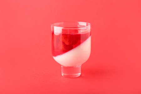 Glass of tasty jelly on color backgroundの写真素材