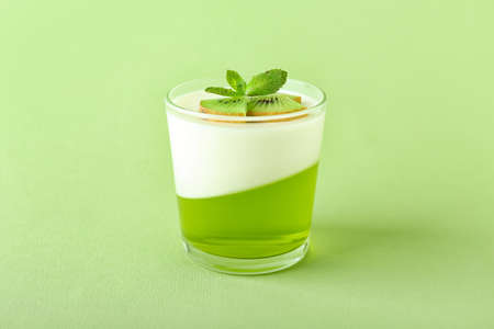 Glass of tasty jelly with kiwi on color backgroundの写真素材