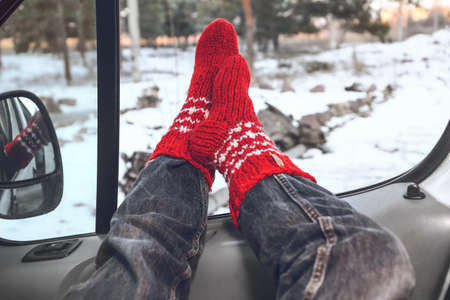 Legs of woman sitting in car on winter dayの写真素材
