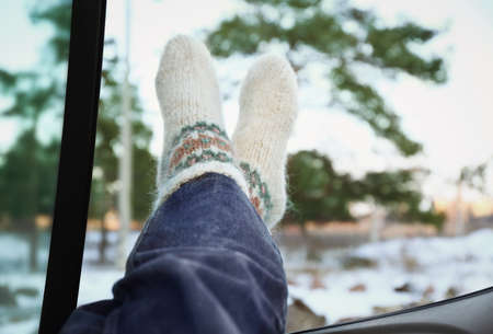 Legs of woman sitting in car on winter dayの写真素材