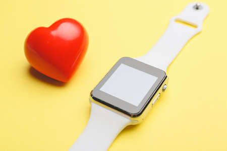 Red heart with fitness band on color backgroundの写真素材