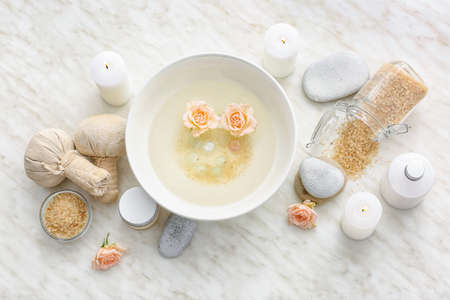 Spa set with bowl of water on light backgroundの写真素材