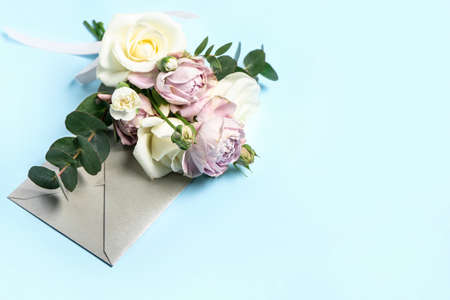 Beautiful flowers and envelope on color background