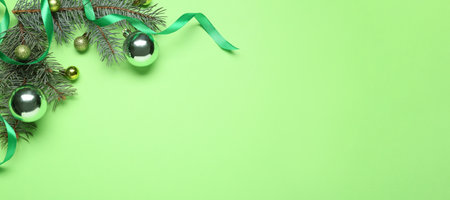 Fir tree branches with Christmas balls on green background with space for textの写真素材