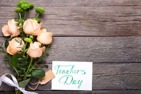 Beautiful flowers and greeting card for Teacher's Day on wooden backgroundの写真素材